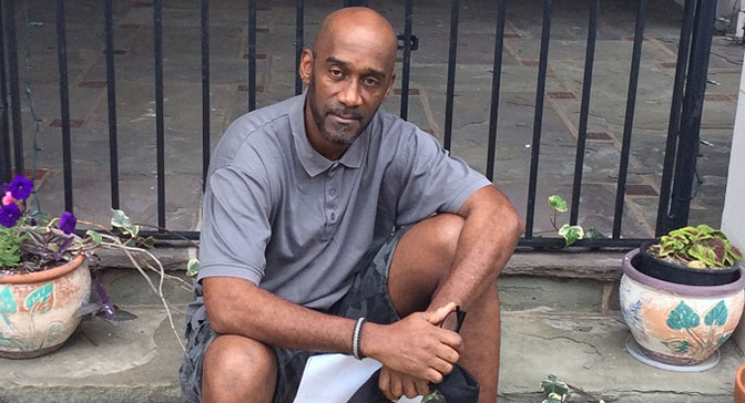 Rod sitting on a stoop in front of flowers