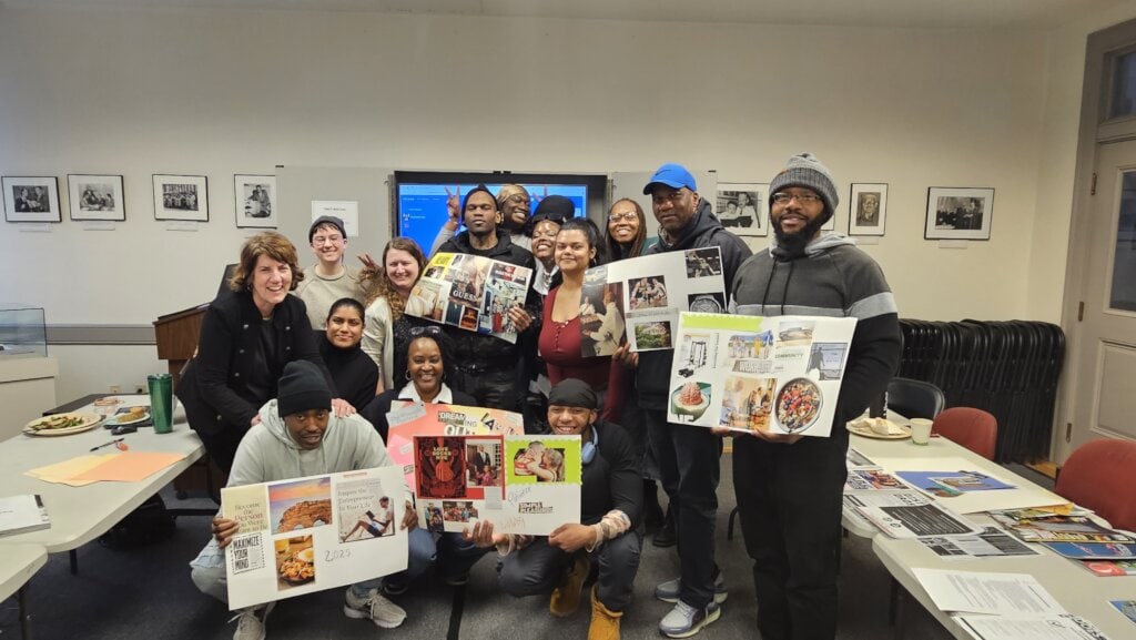 A group of people holding up collages (vision boards)
